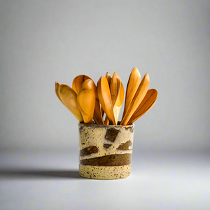 Product photo of wooden soup spoons. Multipal spoons sitting in a ceramic cup