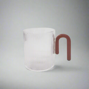 product photo of a clear glass mug with a dark red hook style handle