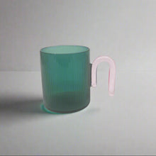 将图片加载到图库查看器，product photo of glass mug. Teal coloured with pink handle
