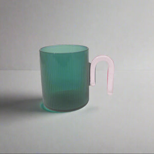 product photo of glass mug. Teal coloured with pink handle