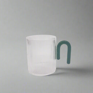 Product photo of a clear glass mug with a teal coloured hook handle