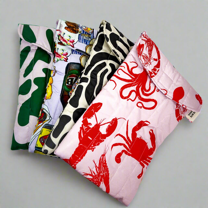 Product photo of puffy laptop bags. All four prints shown