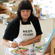 Load image into Gallery viewer, Person painting with a palette and brush in a studio setting
